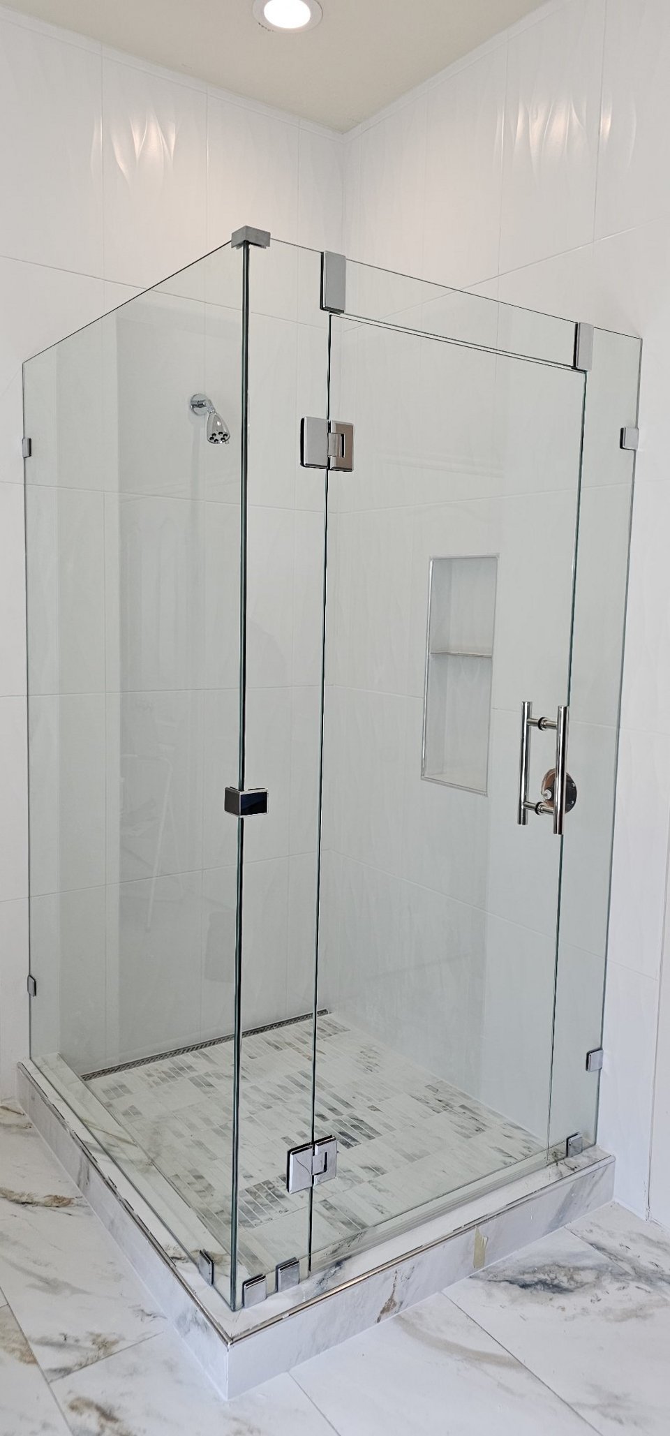 Ejemplo de ángulo 90° sobre muros / muretes de Glas Plus: vidrio clear con herraje cromado en esquina de 90° de azulejo blanco