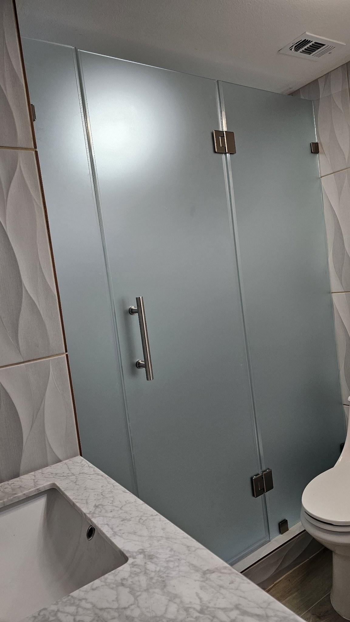 Puerta de bisagras con paneles laterales y vidrio Frosted (opaco) en shower de azulejo con ondas
