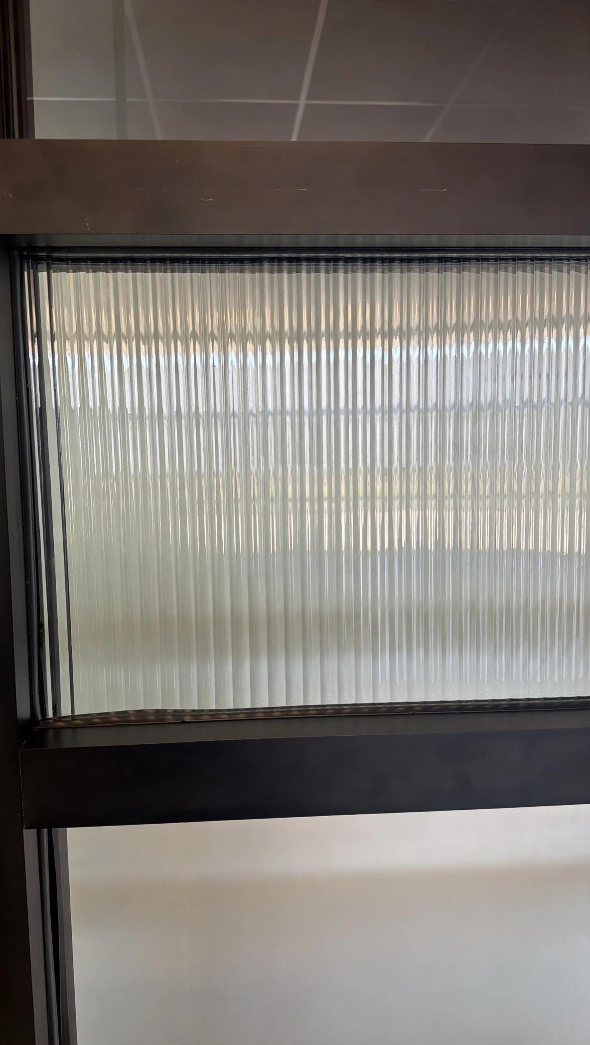Ejemplo de vidrio decorativo para gabinetes de Glas Plus: vidrio estriado (reeded) en marco oscuro