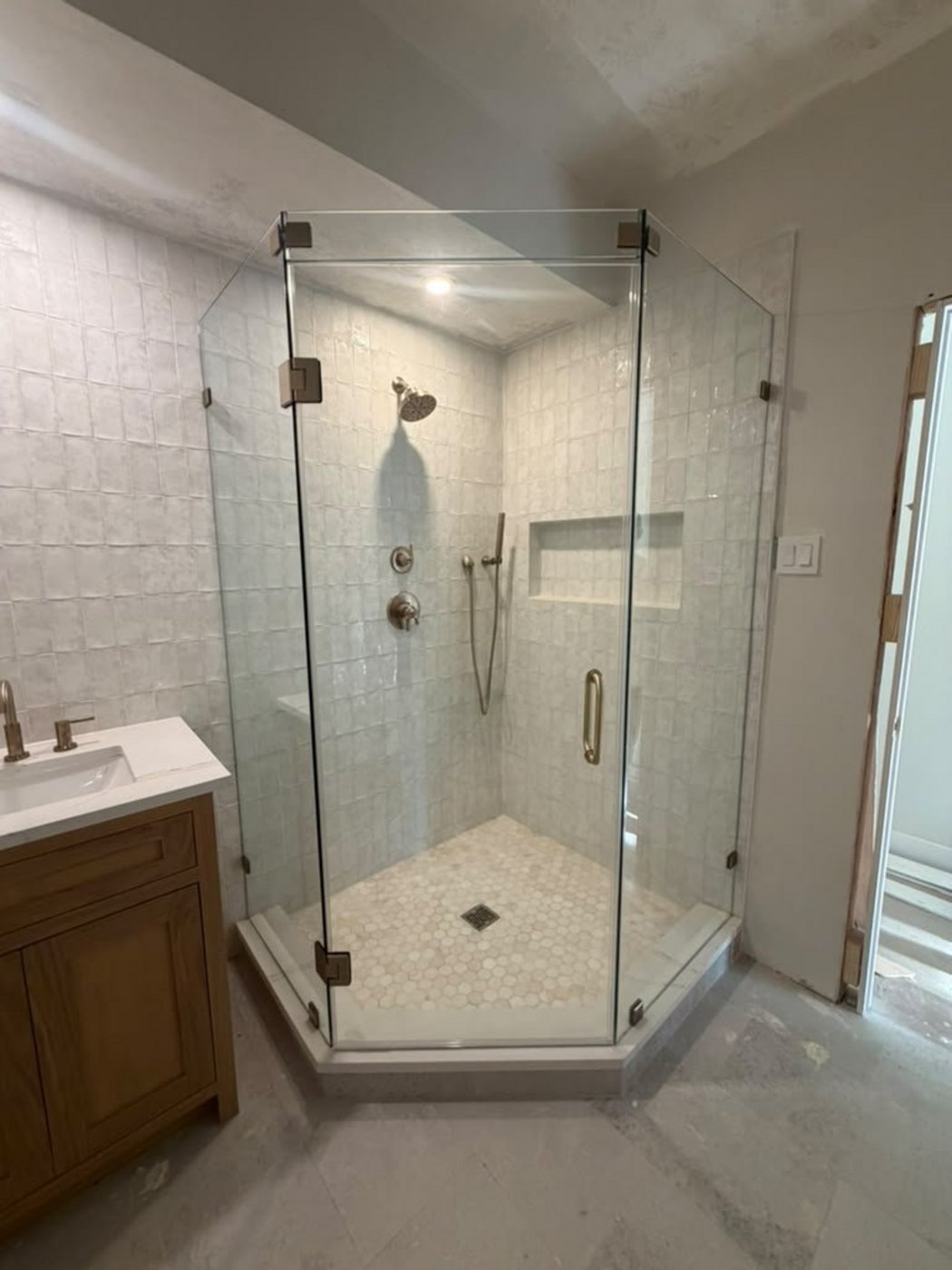 Trabajo de Glas Plus: ángulo 135° neo-angle con herraje dorado en un shower de azulejo blanco