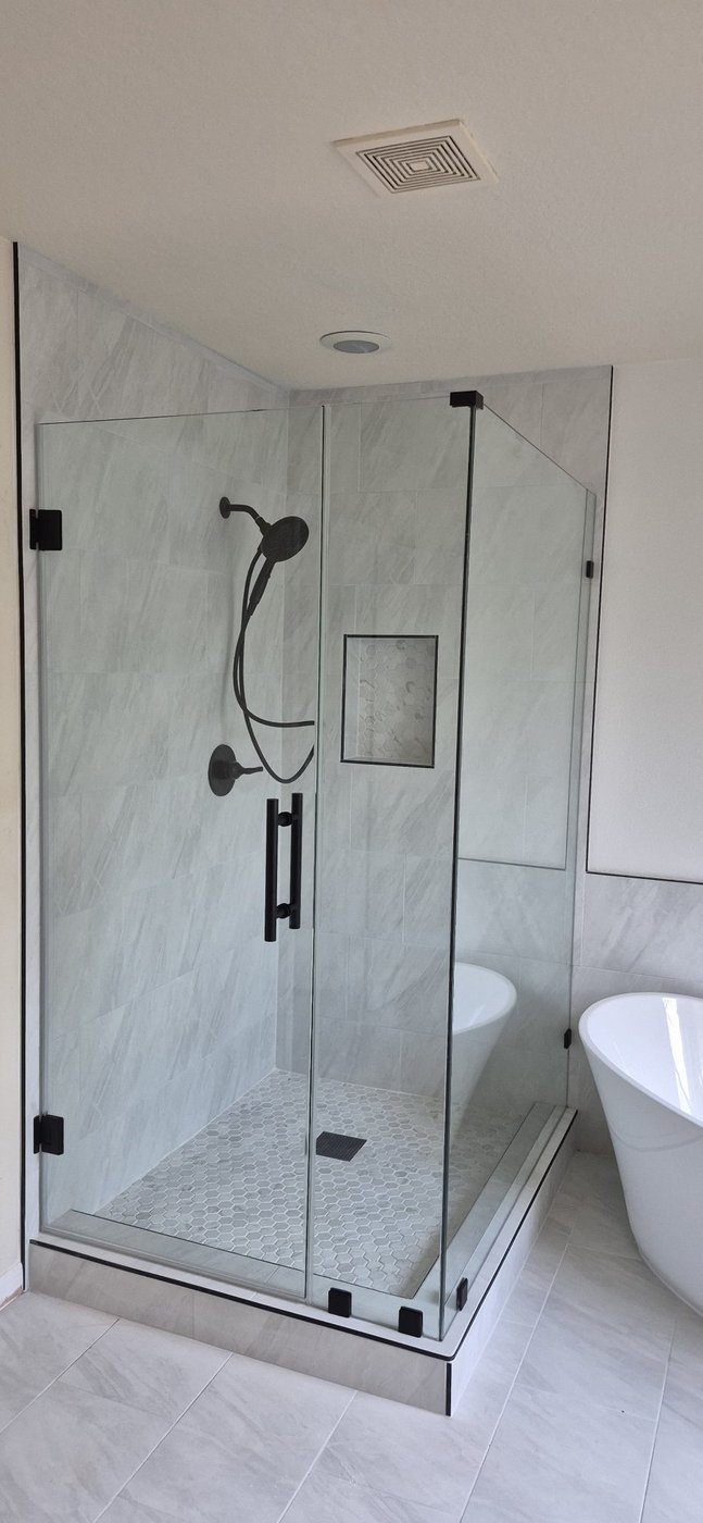 Trabajo de Glas Plus: ángulo 90° con herraje negro en un baño de mármol claro