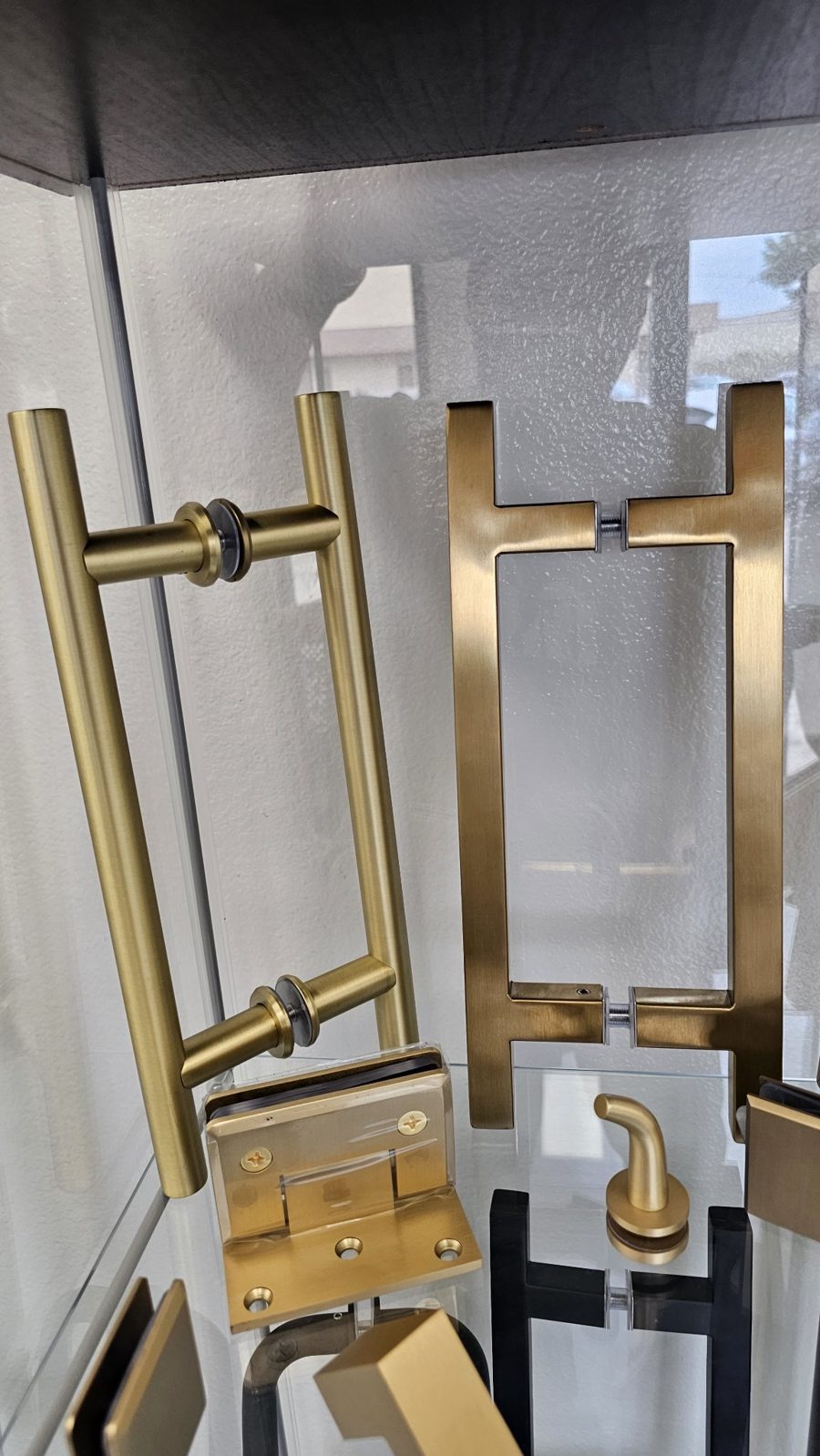 Juego de herrajes brush gold de Glas Plus en vitrina: manijas y bisagras en oro cepillado