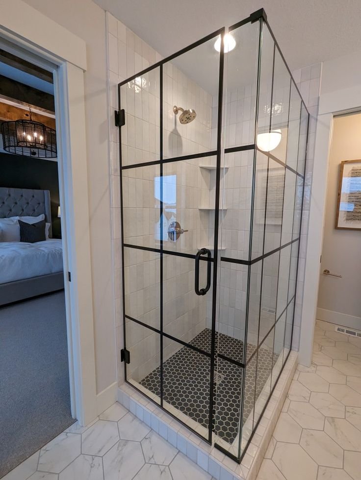 Trabajo de Glas Plus: estilo industrial en esquina con marco y rejilla negros, en shower de azulejo claro con piso hexagonal
