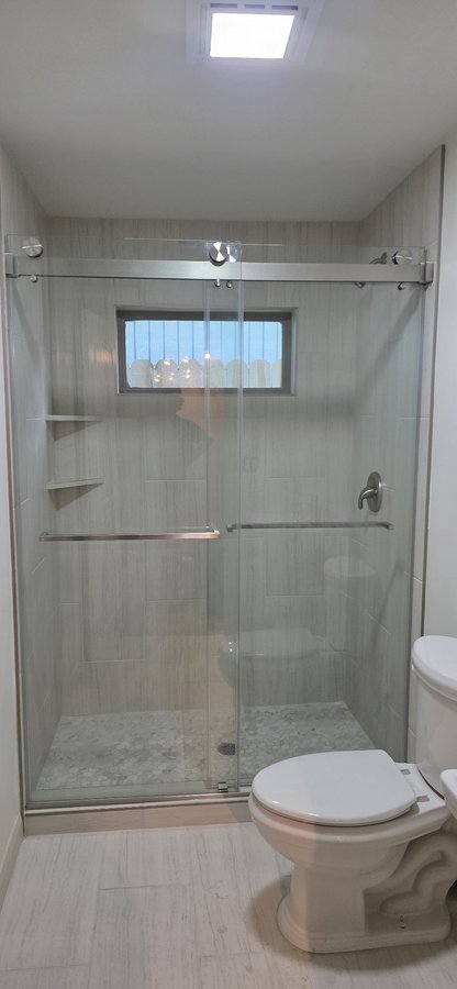 Sliding doble puerta con riel cromado en shower de azulejo subway con nicho