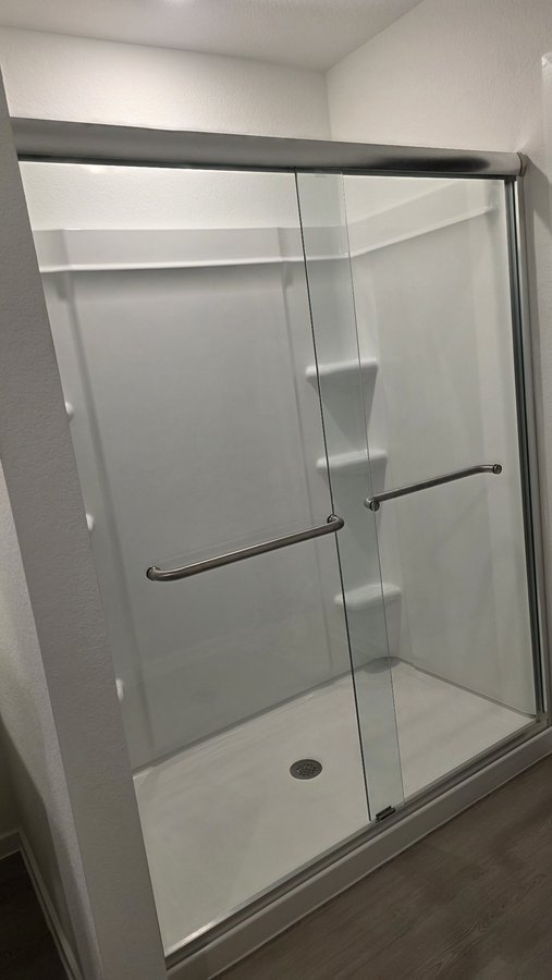 Sliding doble puerta con herraje de níquel en shower blanco con banco